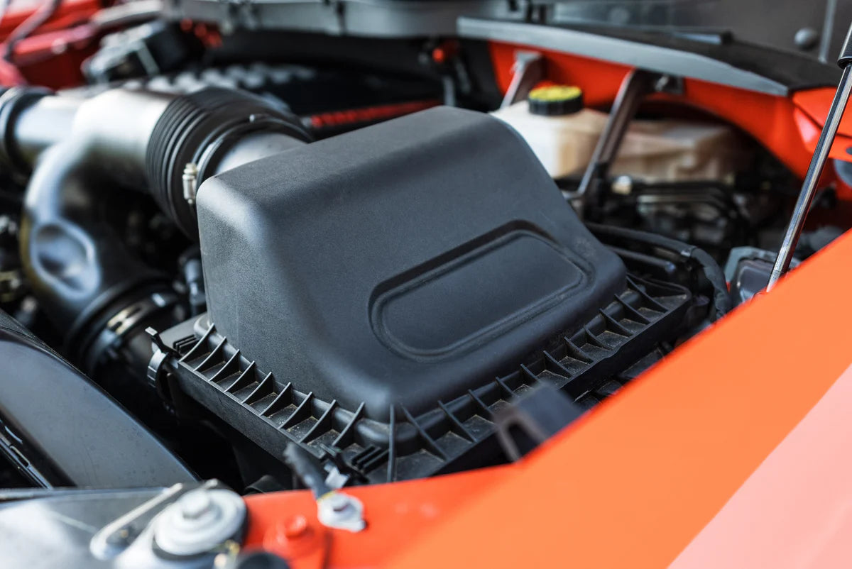 roush cold air intake installed in orange vehicle 