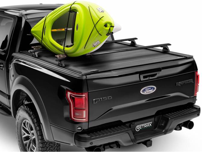 Powertrax Pro XR Cover shown with the rack accessory and a kayak attached to the rack on a black Raptor 